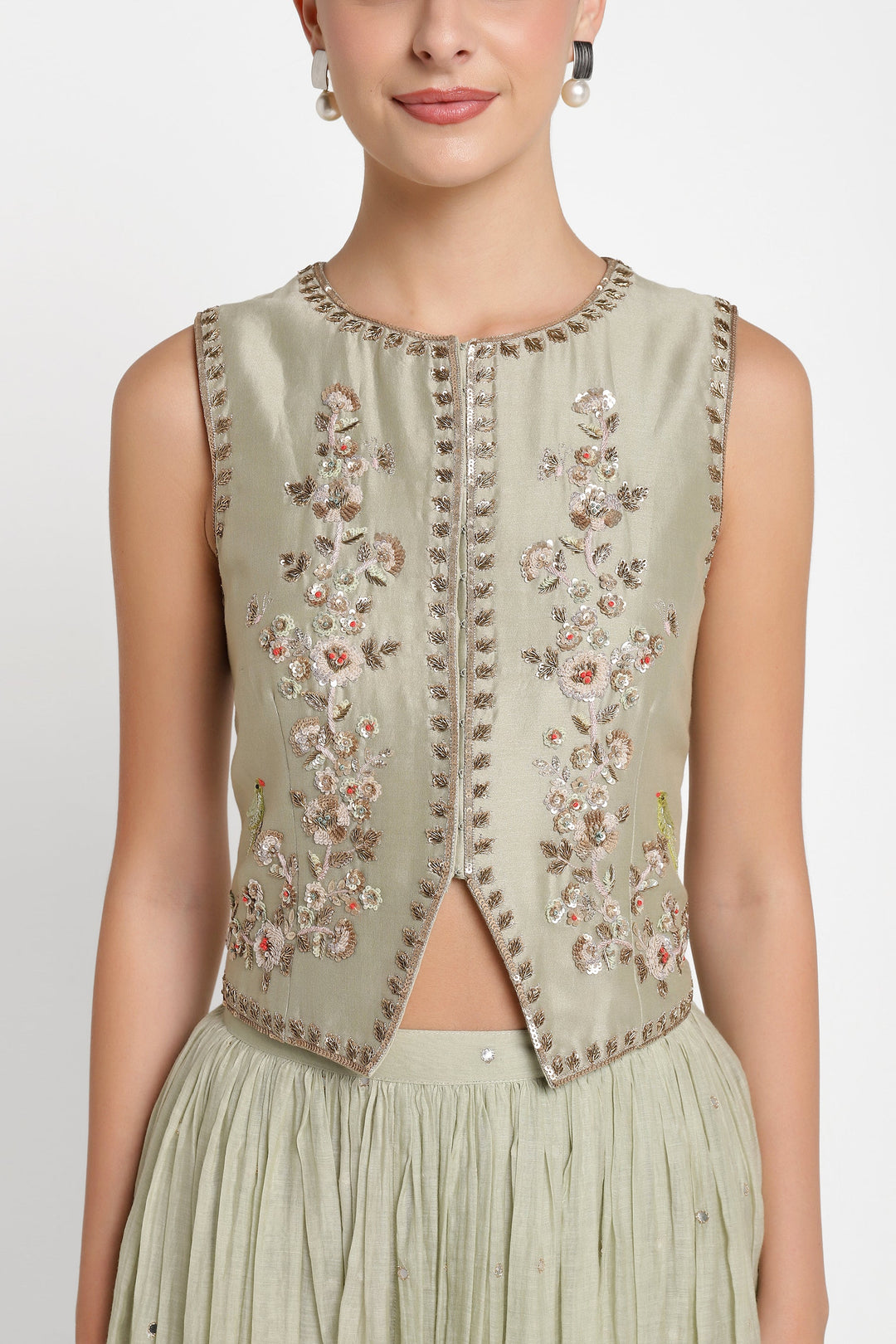 Light green embroidered vest worn by a model on a white background
