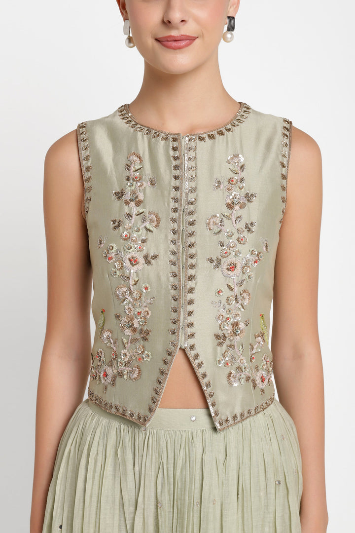 Light green embroidered vest worn by a model on a white background