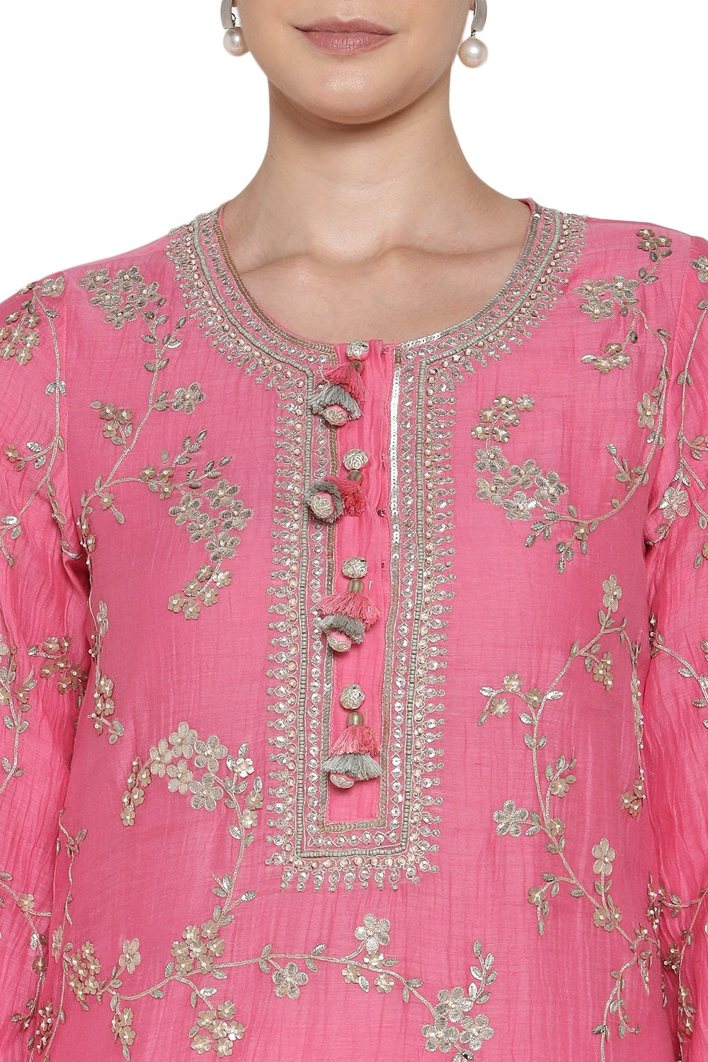 Close-up of a pink embroidered garment with floral patterns on a white background