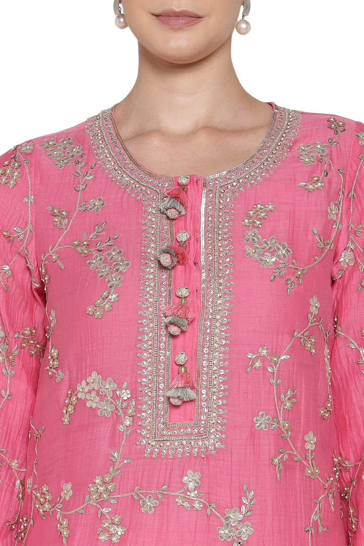 Close-up of a pink embroidered garment with floral patterns on a white background