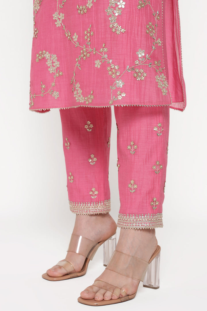 Pink embroidered outfit with matching shoes on a white background