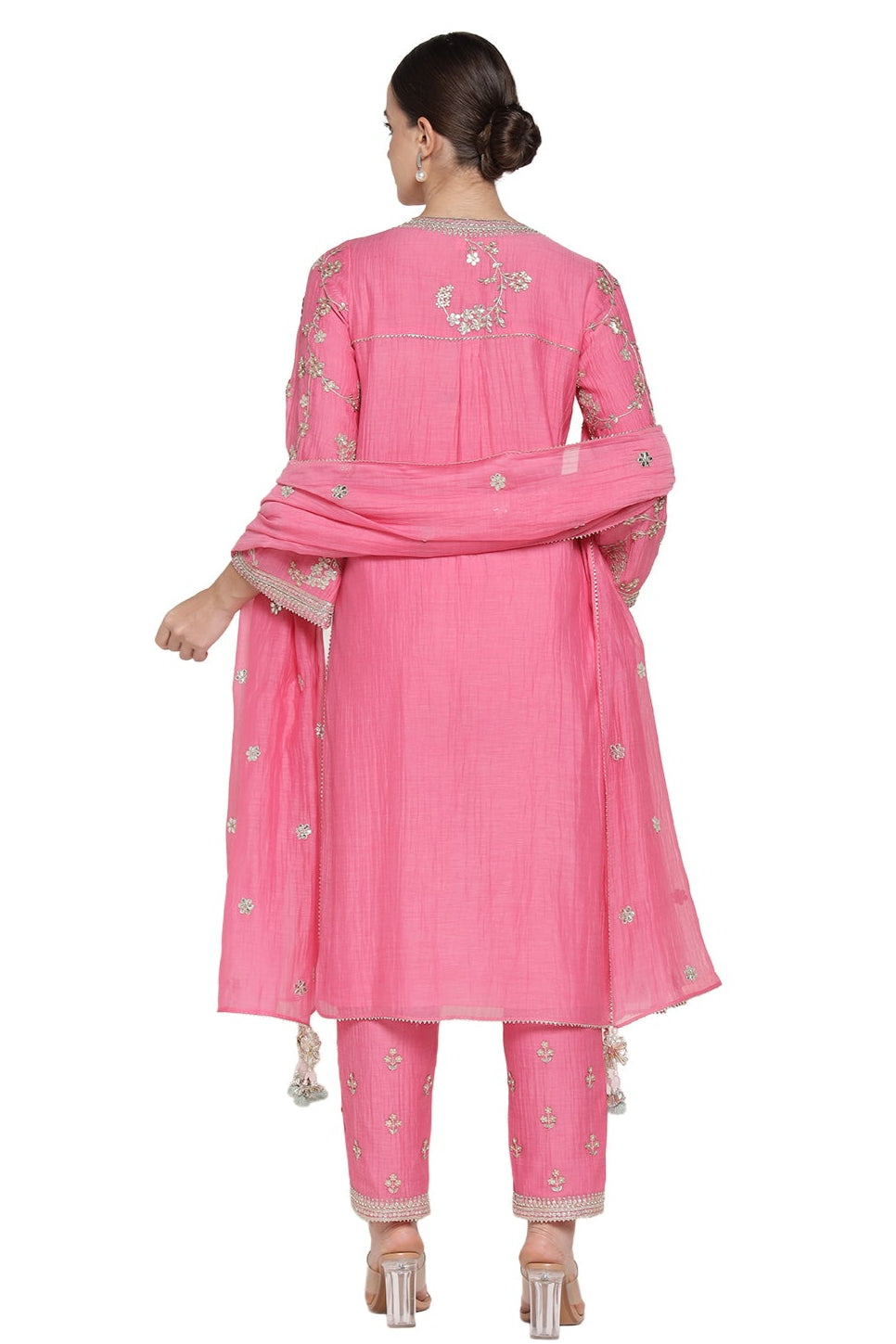 Woman wearing a pink traditional outfit with embroidery on a white background