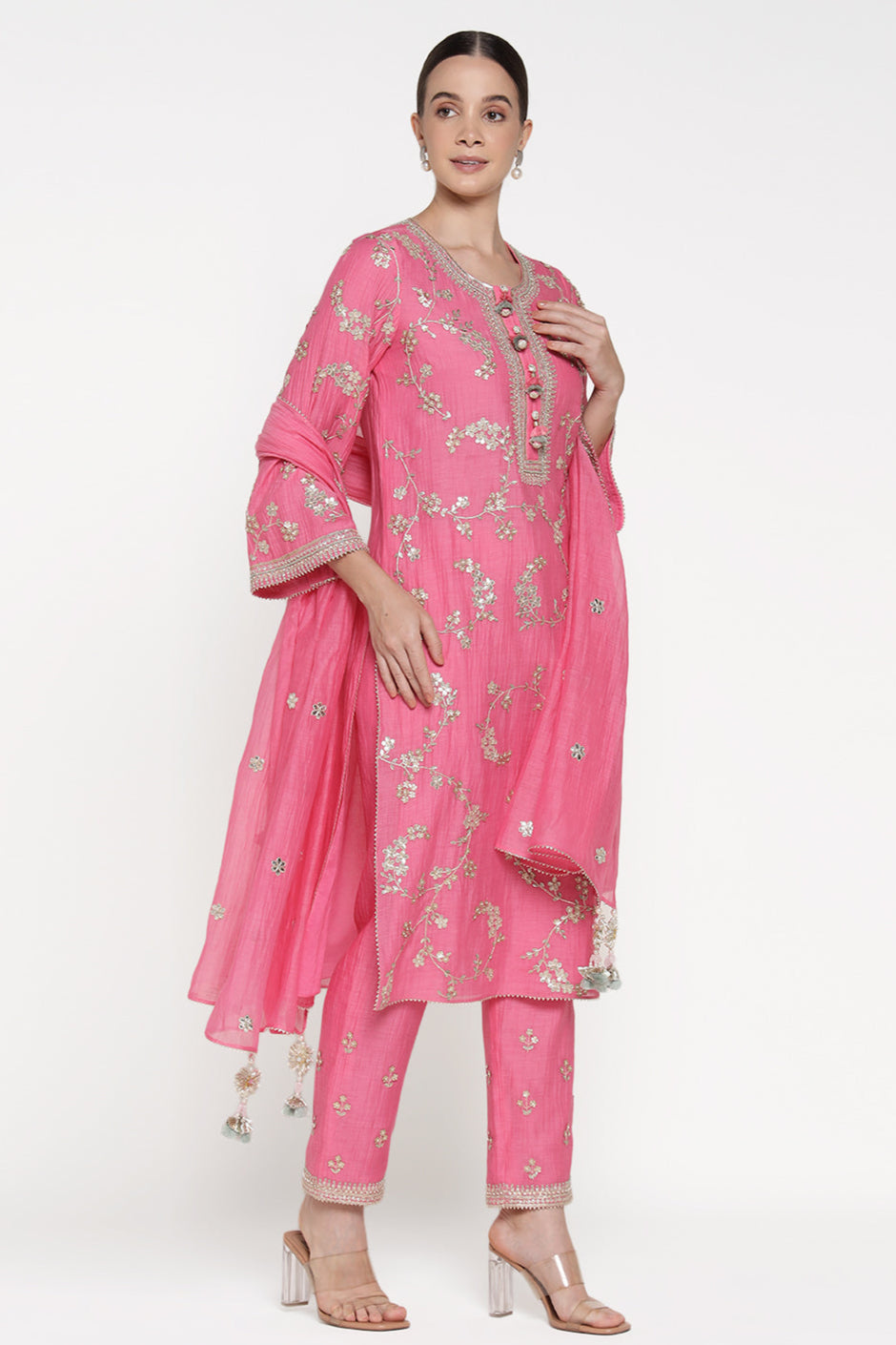 Woman wearing a pink traditional outfit with floral patterns on a white background