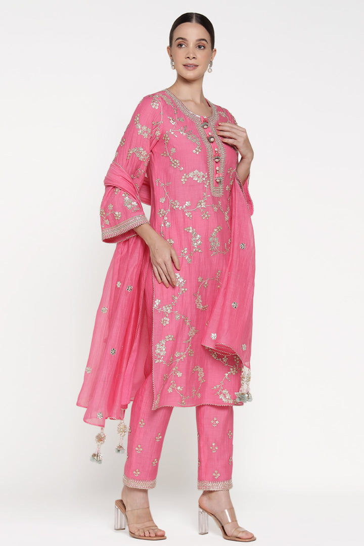 Woman wearing a pink traditional outfit with floral patterns on a white background