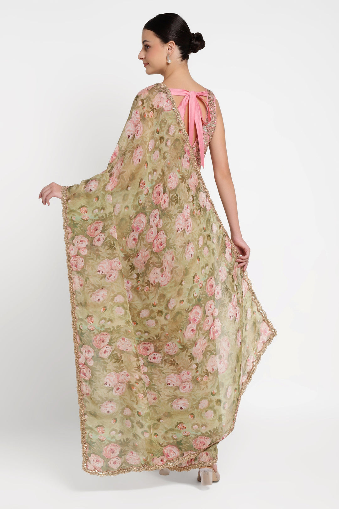 Woman wearing a floral dress with a pink bow on a white background