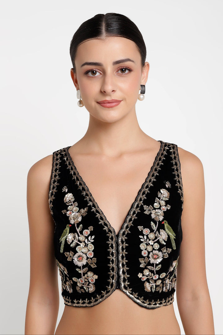 Woman wearing a black embroidered top on a white background