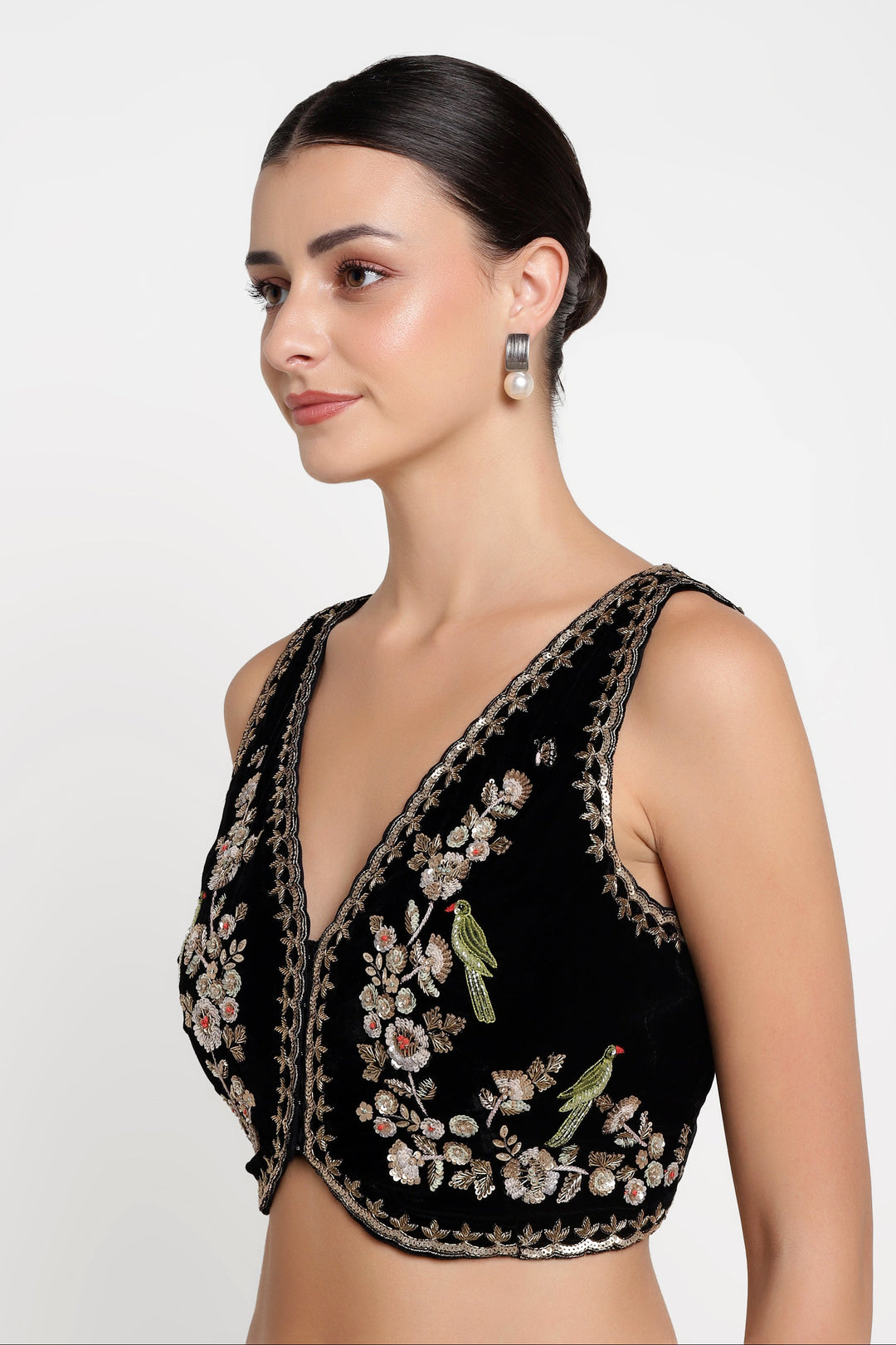 Woman wearing a black embroidered top on a white background