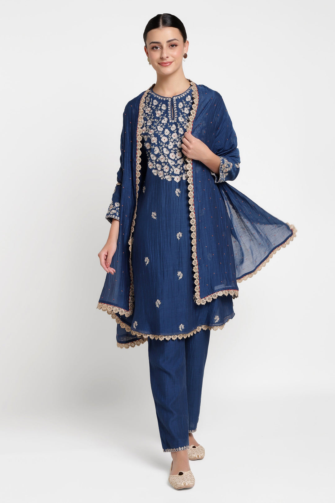 Woman wearing a blue embroidered outfit with a matching dupatta on a white background