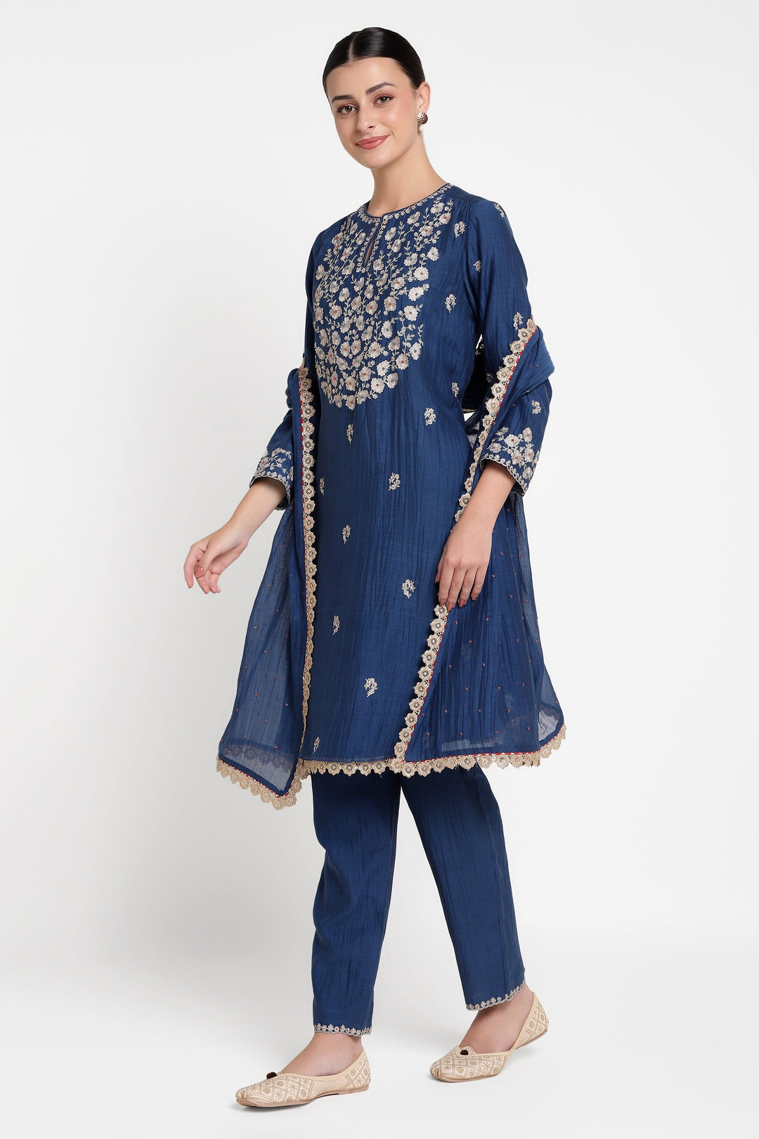 Woman wearing a blue embroidered traditional outfit on a white background