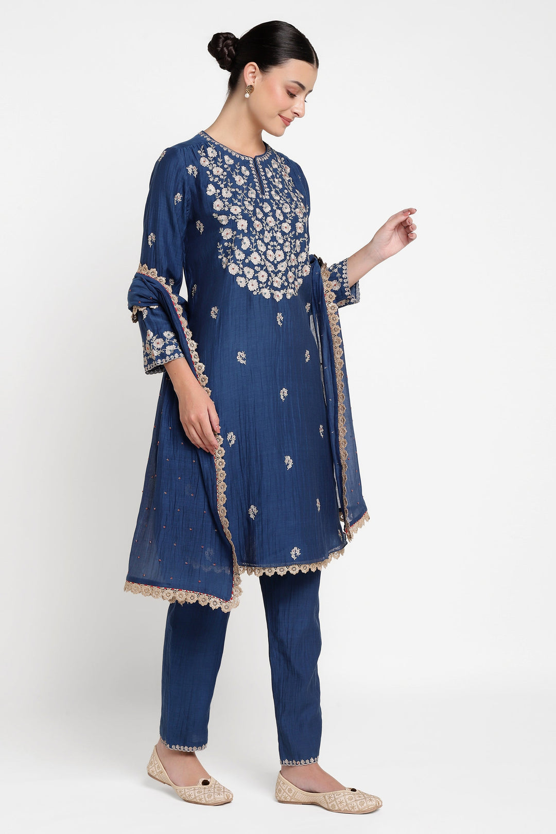 Woman wearing a blue embroidered traditional outfit on a white background