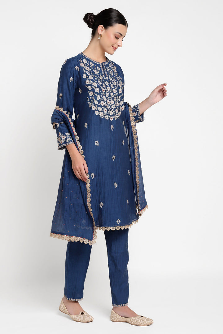 Woman wearing a blue embroidered traditional outfit on a white background