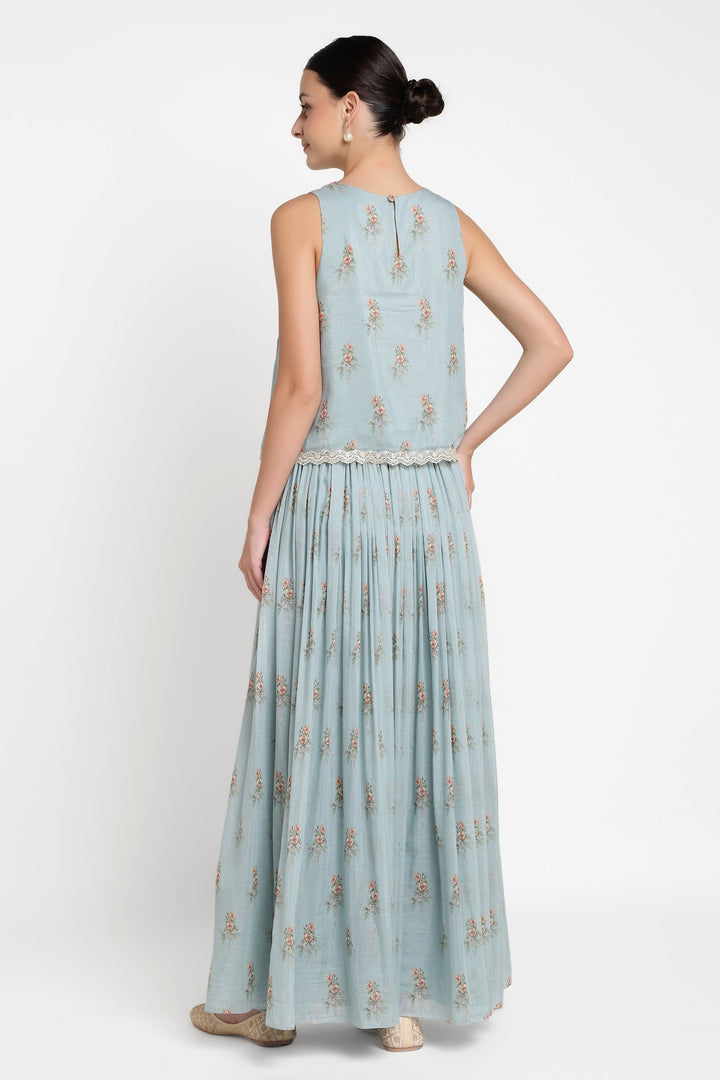 Woman wearing a light blue dress with floral patterns on a white background