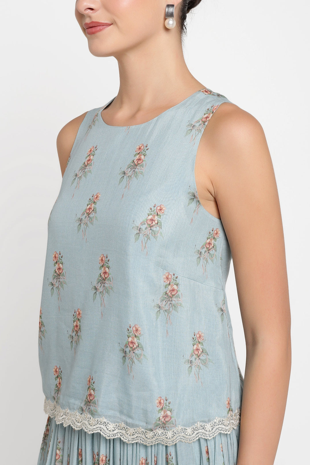 Light blue sleeveless top with floral patterns on a plain background