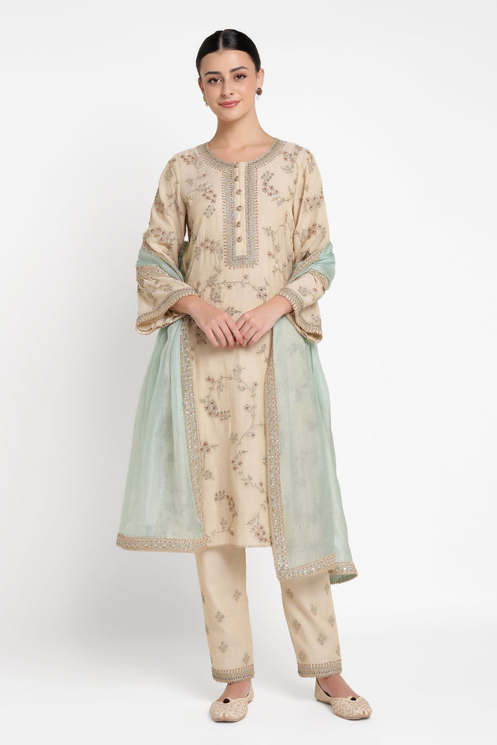 Woman wearing a traditional outfit with a beige and green color scheme on a white background