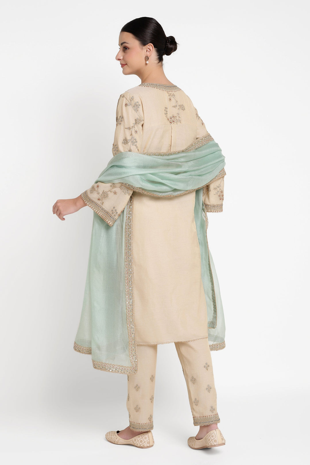 Woman wearing a traditional outfit with a light green dupatta on a white background