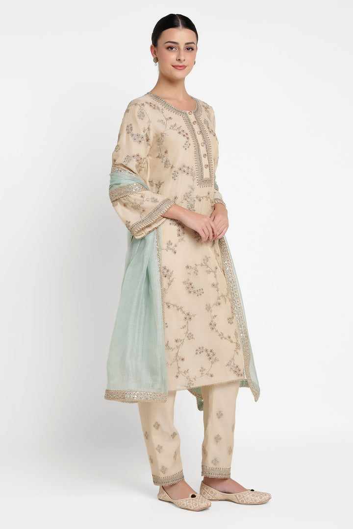 Woman wearing a beige floral kurta with a light green dupatta on a white background