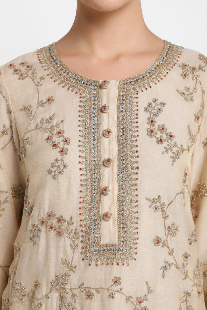 Beige embroidered dress with intricate patterns on a plain background