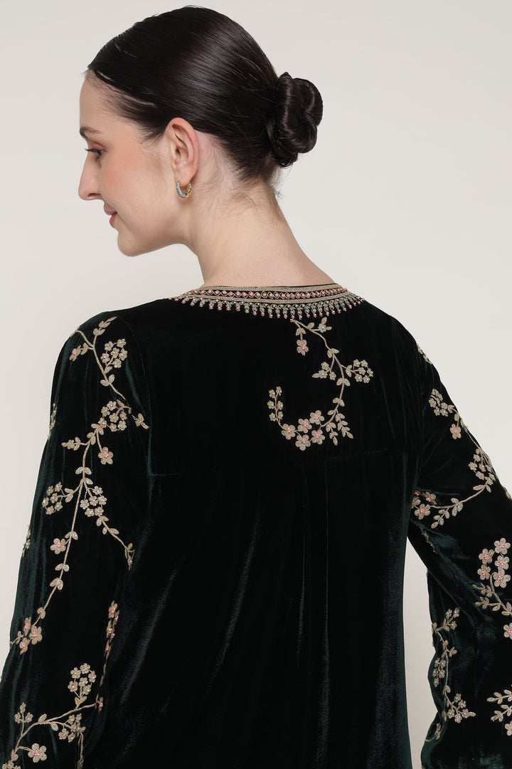 Black velvet outfit with floral embroidery on a plain background