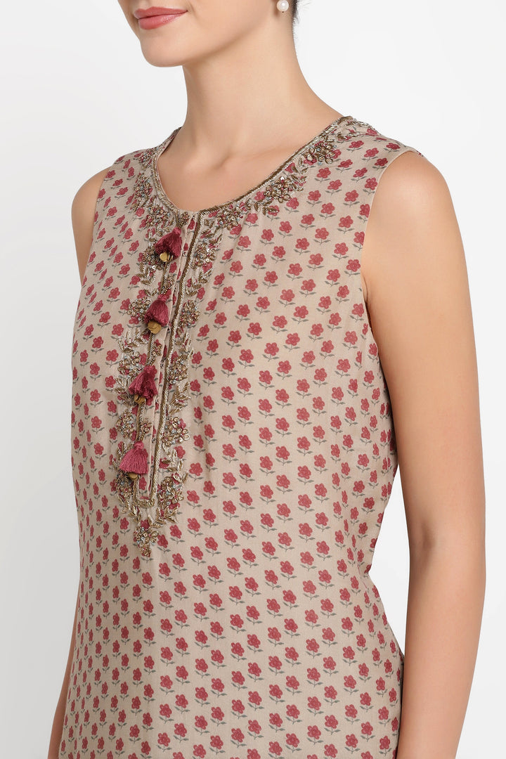 Woman wearing a sleeveless top with floral pattern and embroidered details on a white background