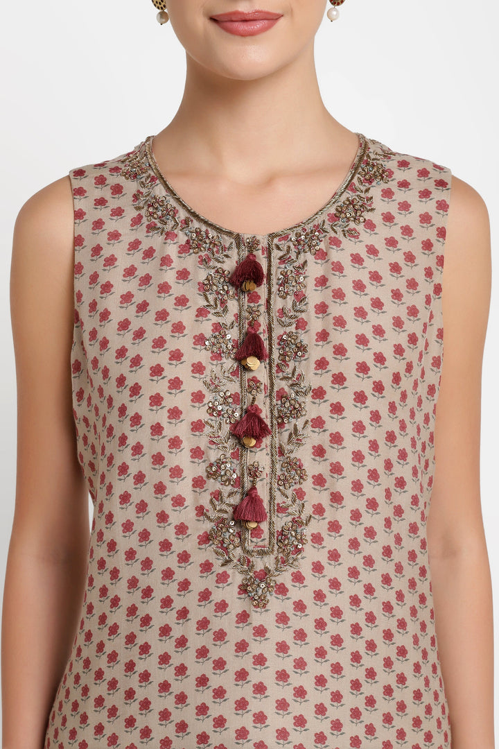 Beige sleeveless top with red floral pattern and decorative buttons on a white background