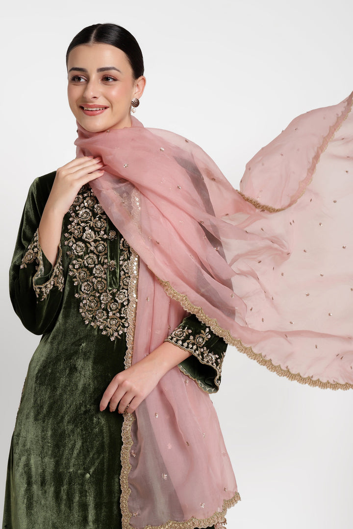 Woman holding a pink embroidered scarf against a white background