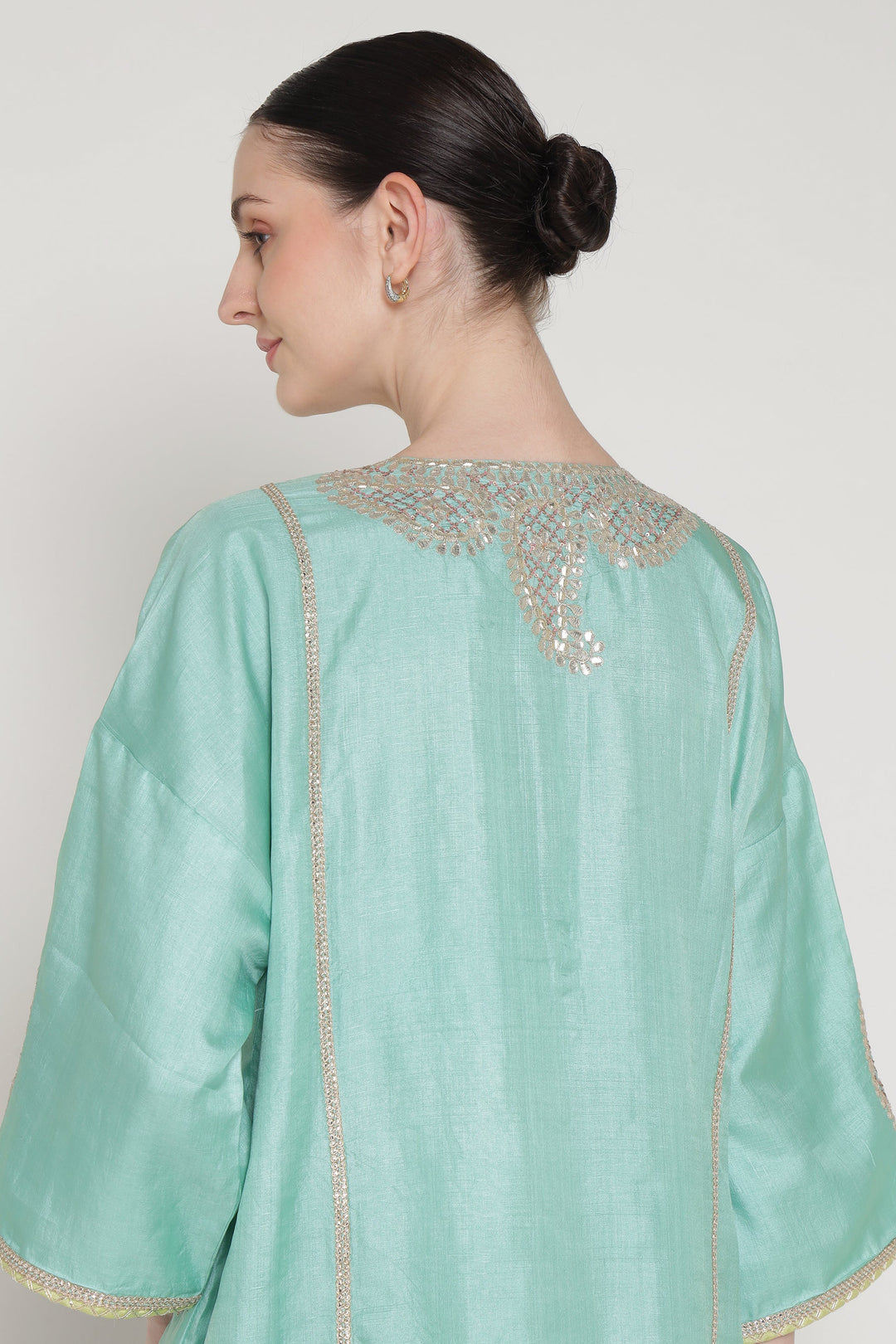 Light blue traditional outfit with intricate detailing on a plain background