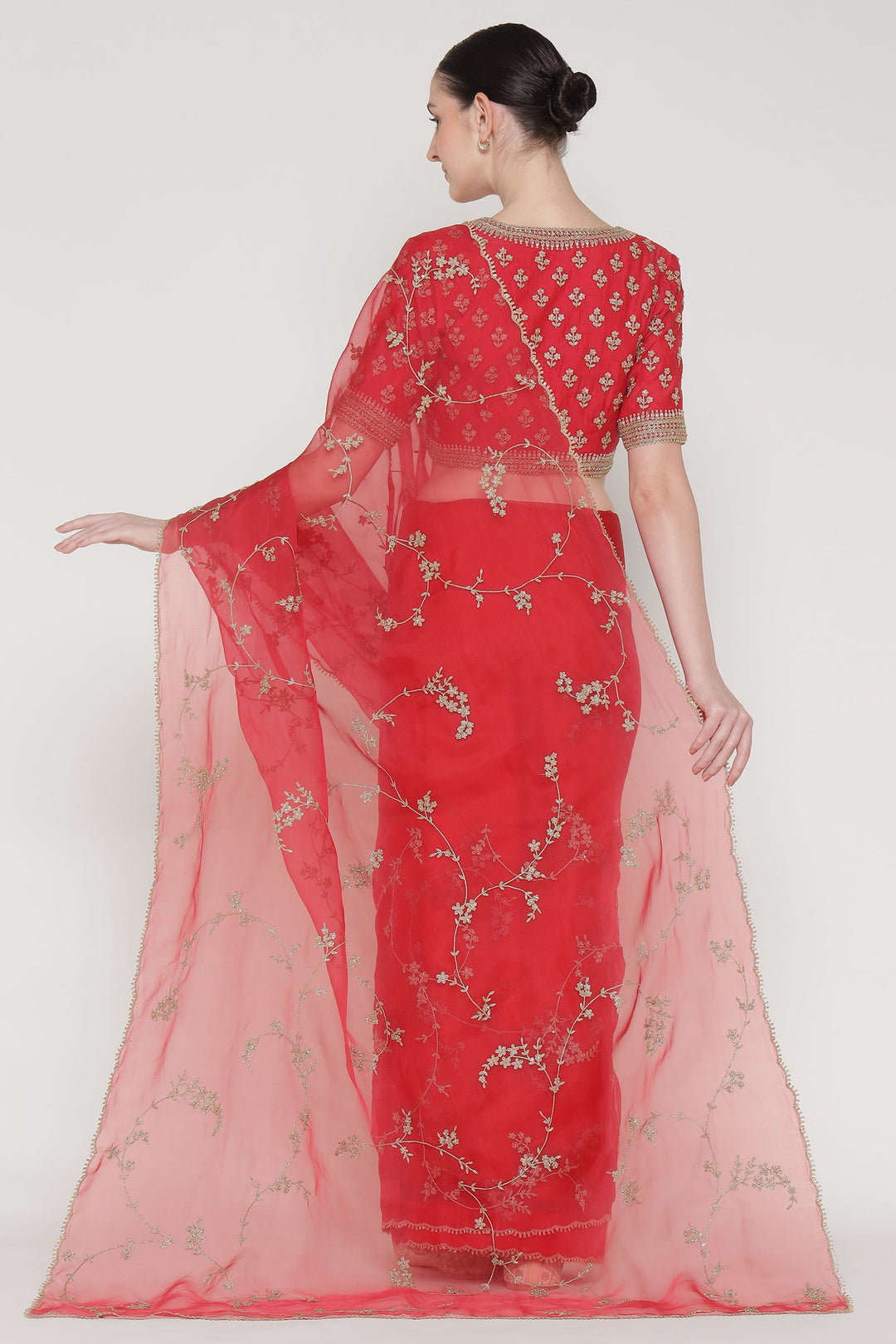 Red saree with floral patterns on a white background