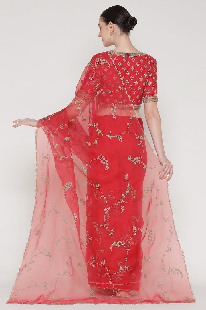 Red saree with floral patterns on a white background