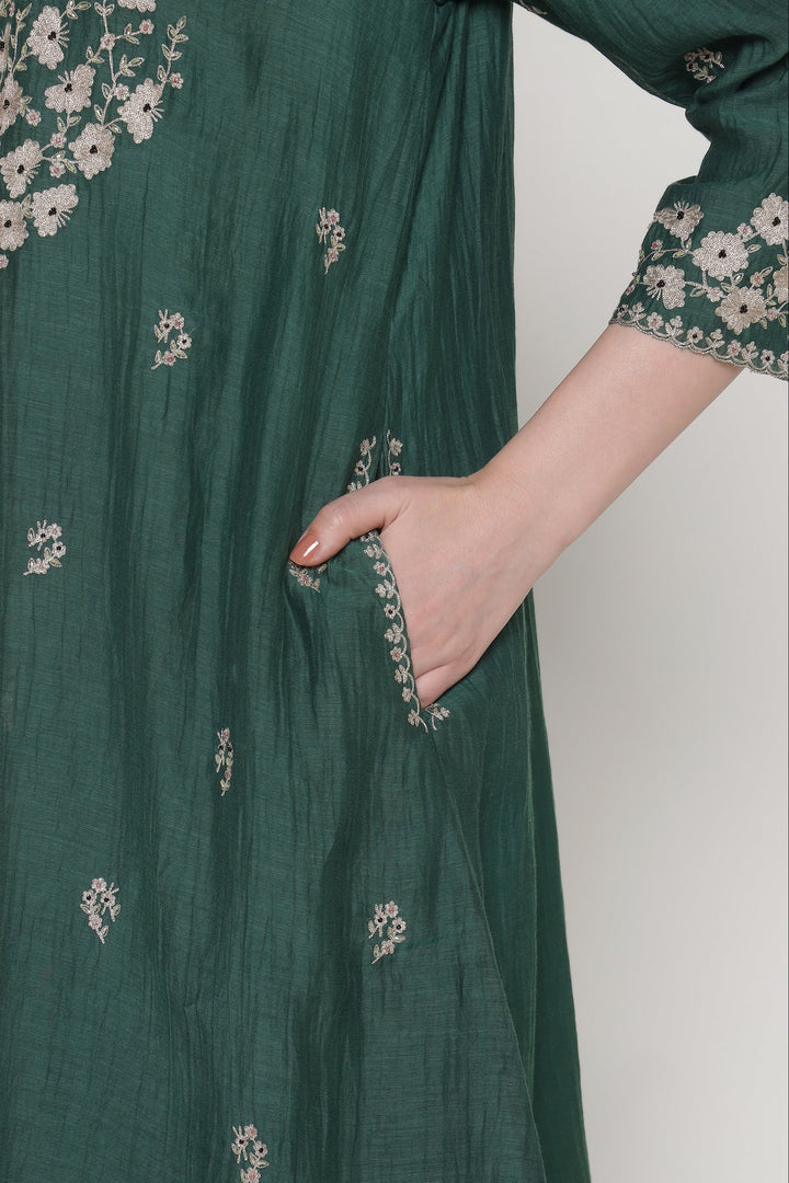 Green dress with floral embroidery on a plain background