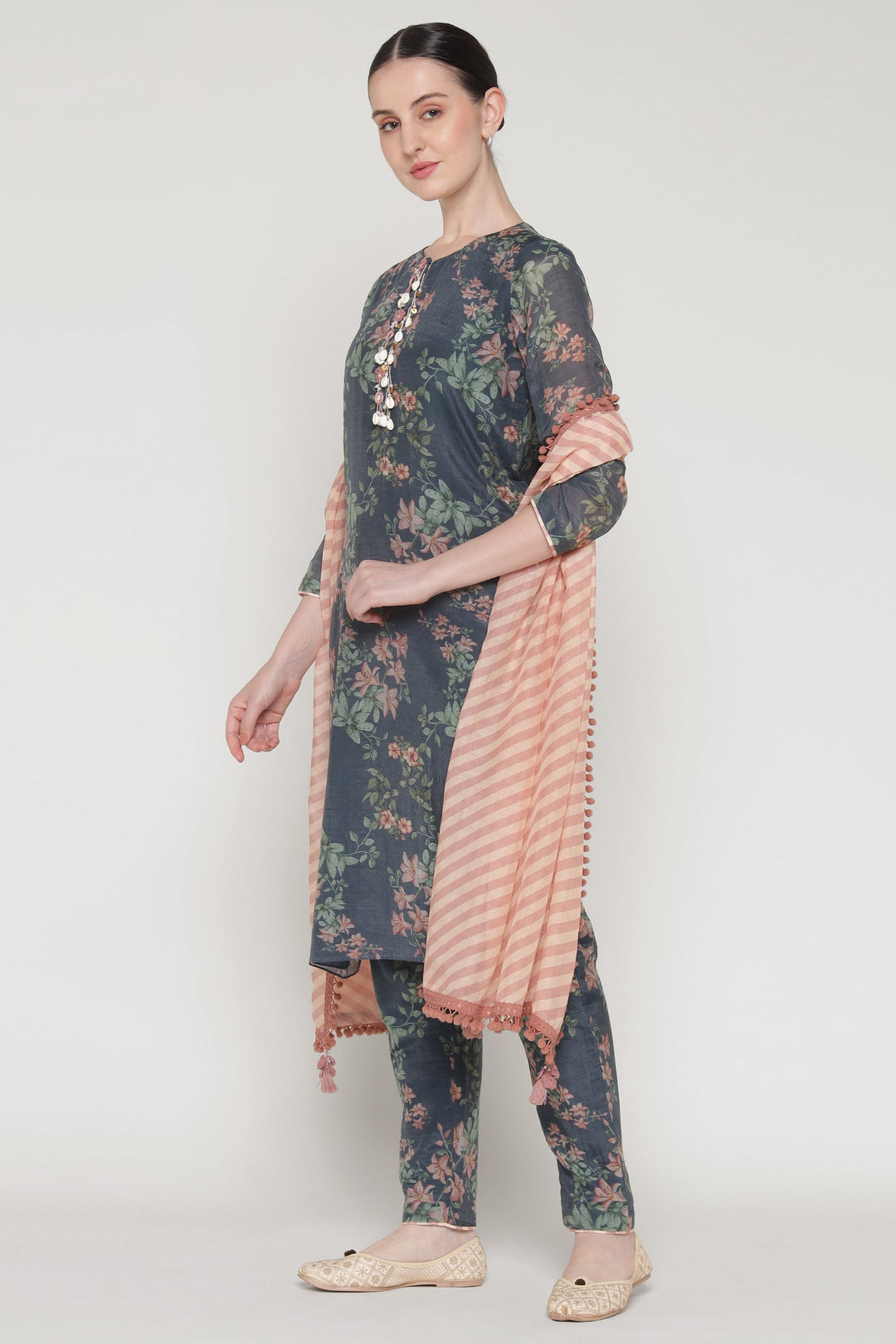 Woman wearing a floral kurta with a matching dupatta on a white background