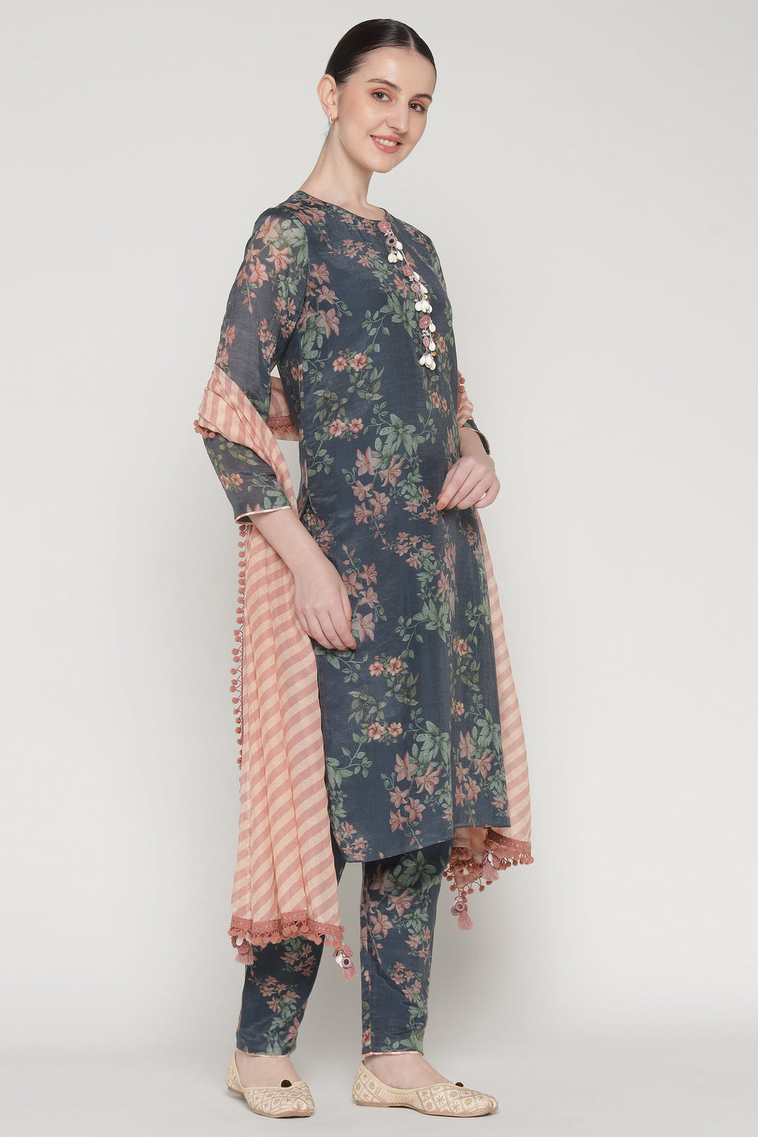 Woman wearing a floral dress with a matching dupatta on a white background