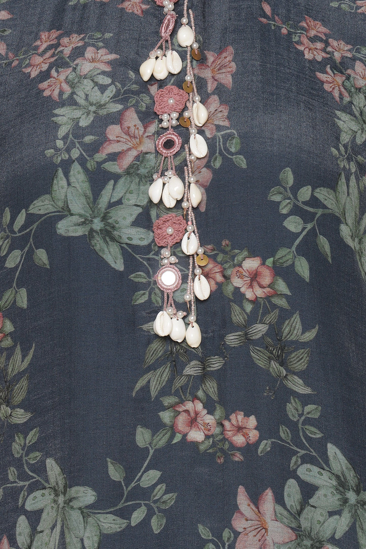 Decorative necklace with shell elements on a floral fabric background