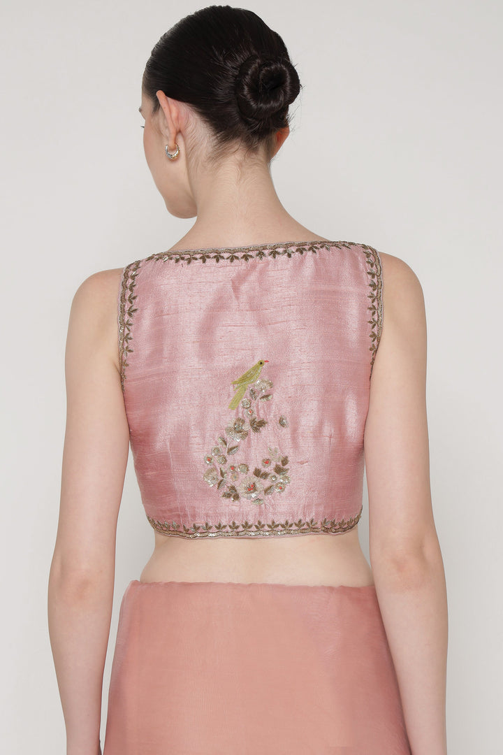 Pink embroidered blouse worn by a model on a plain background