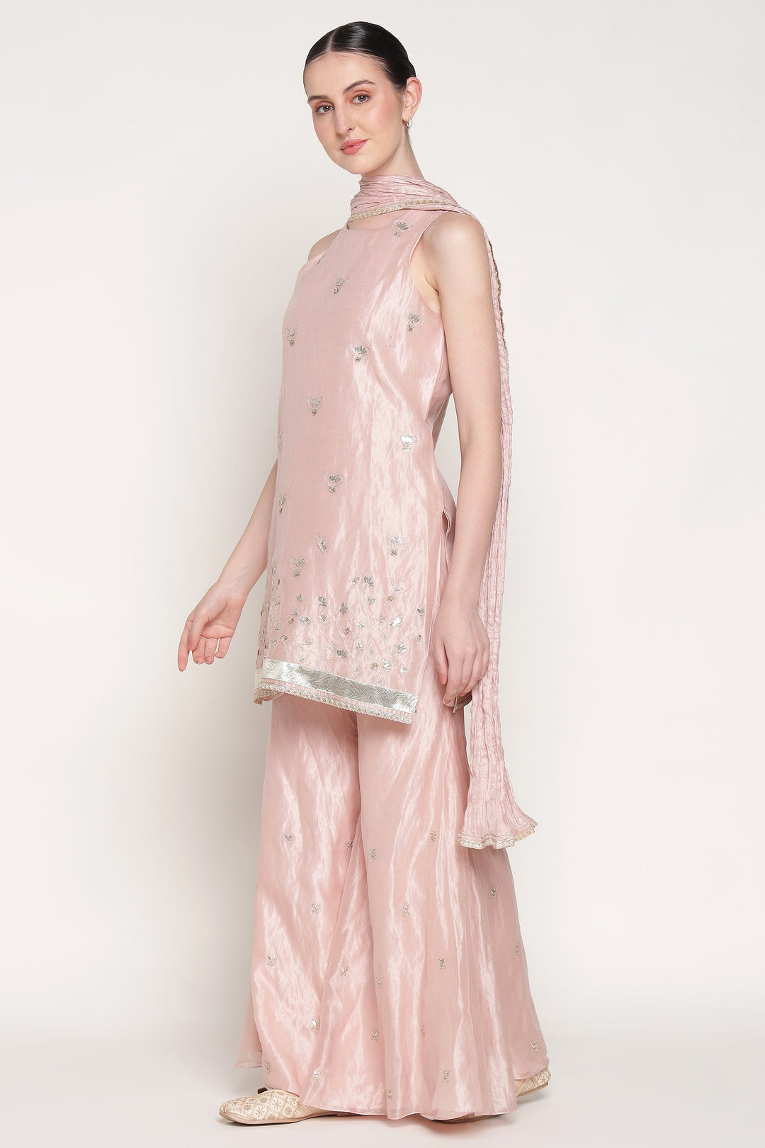 Woman wearing a pink traditional outfit with a plain background