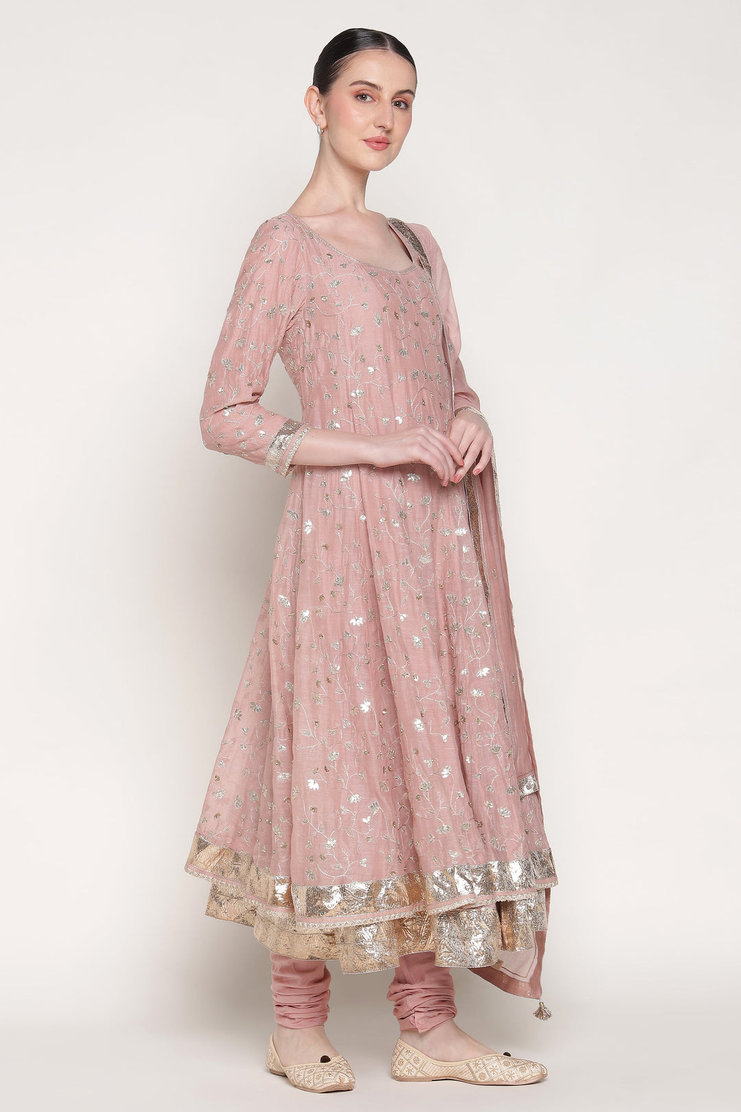 Woman wearing a pink traditional outfit with silver details on a white background