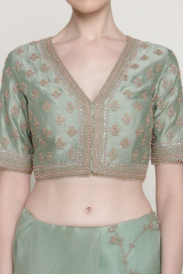 Light green blouse with intricate gold embroidery on a plain background