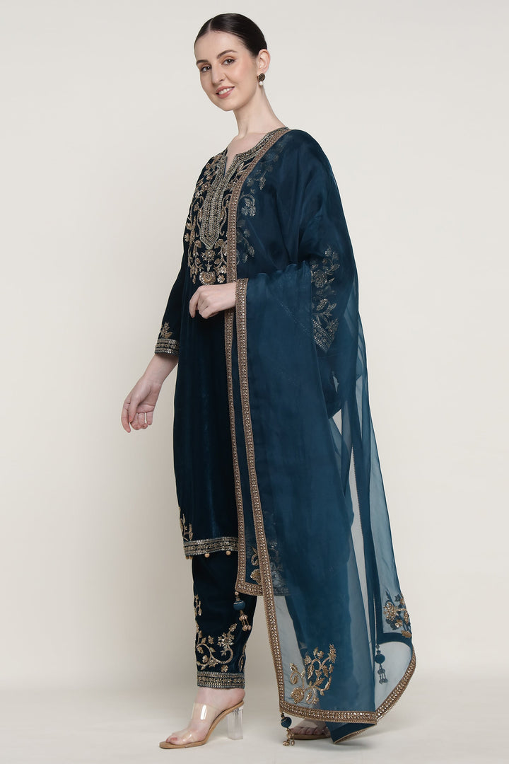 Woman wearing a blue embroidered traditional outfit on a white background