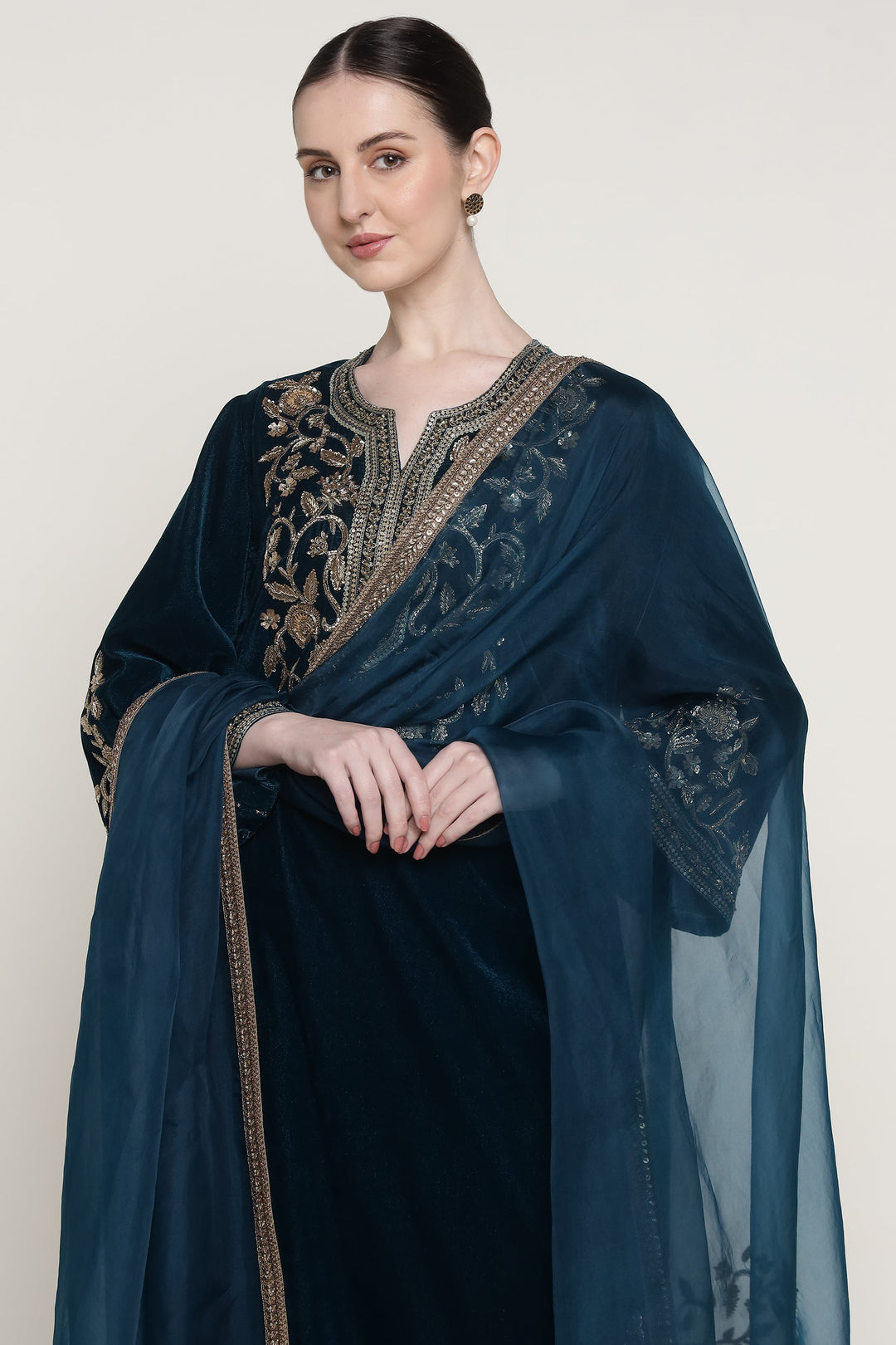 Woman wearing a dark blue embroidered shawl on a white background