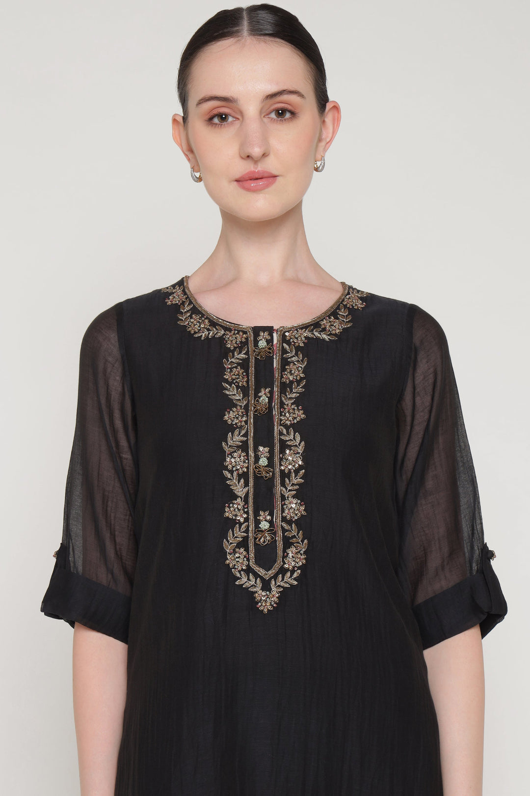 Black dress with embroidery on a plain background