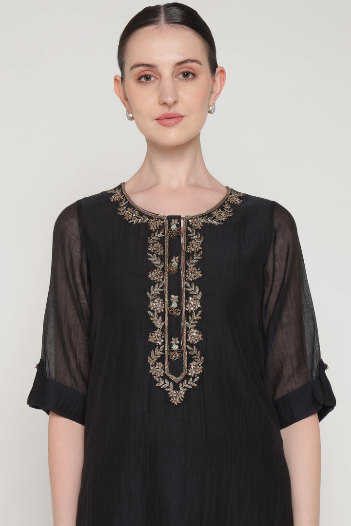 Black dress with embroidery on a plain background