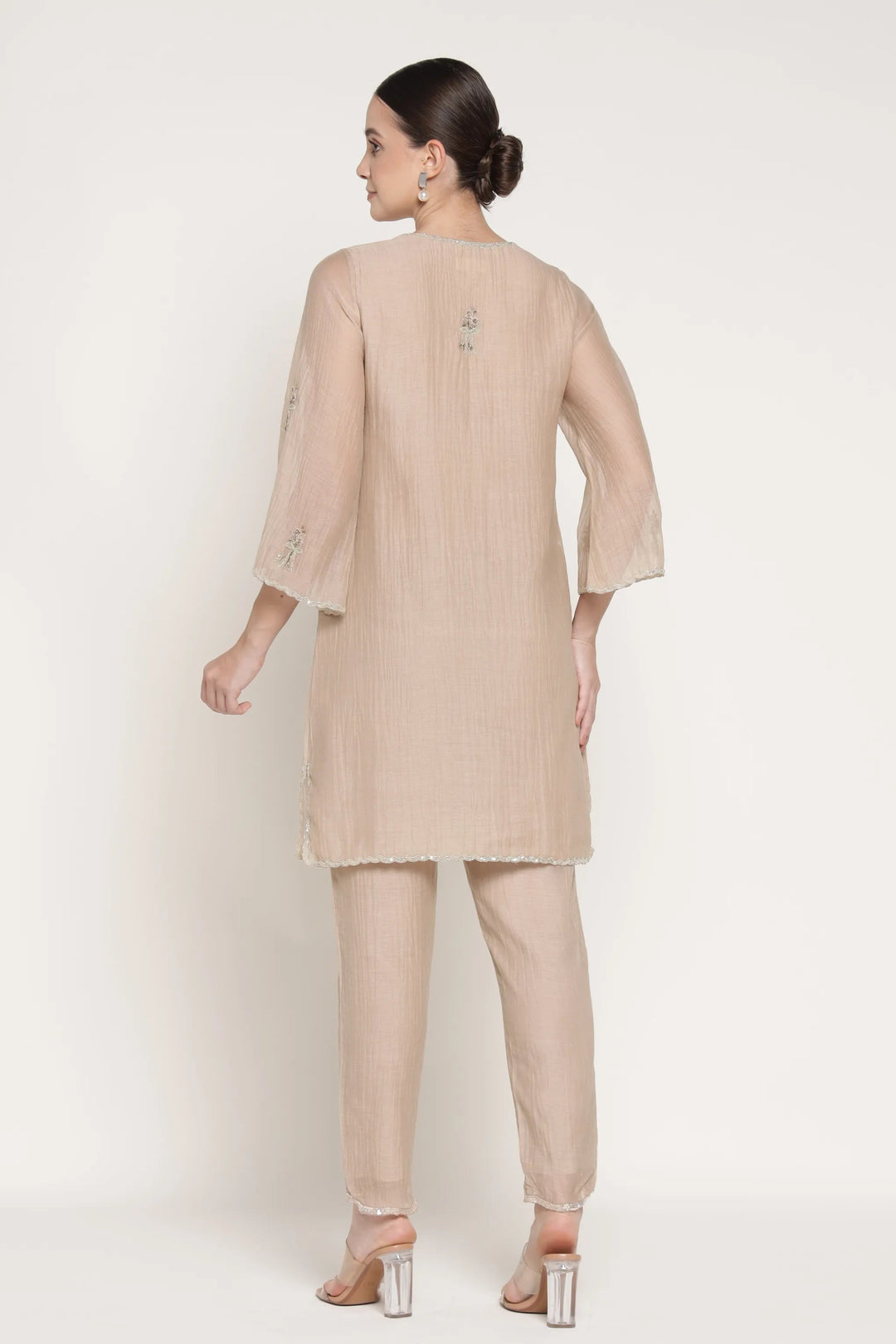 Woman wearing a beige outfit on a white background