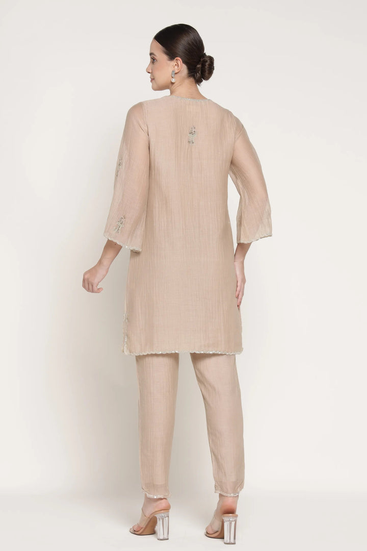 Woman wearing a beige outfit on a white background