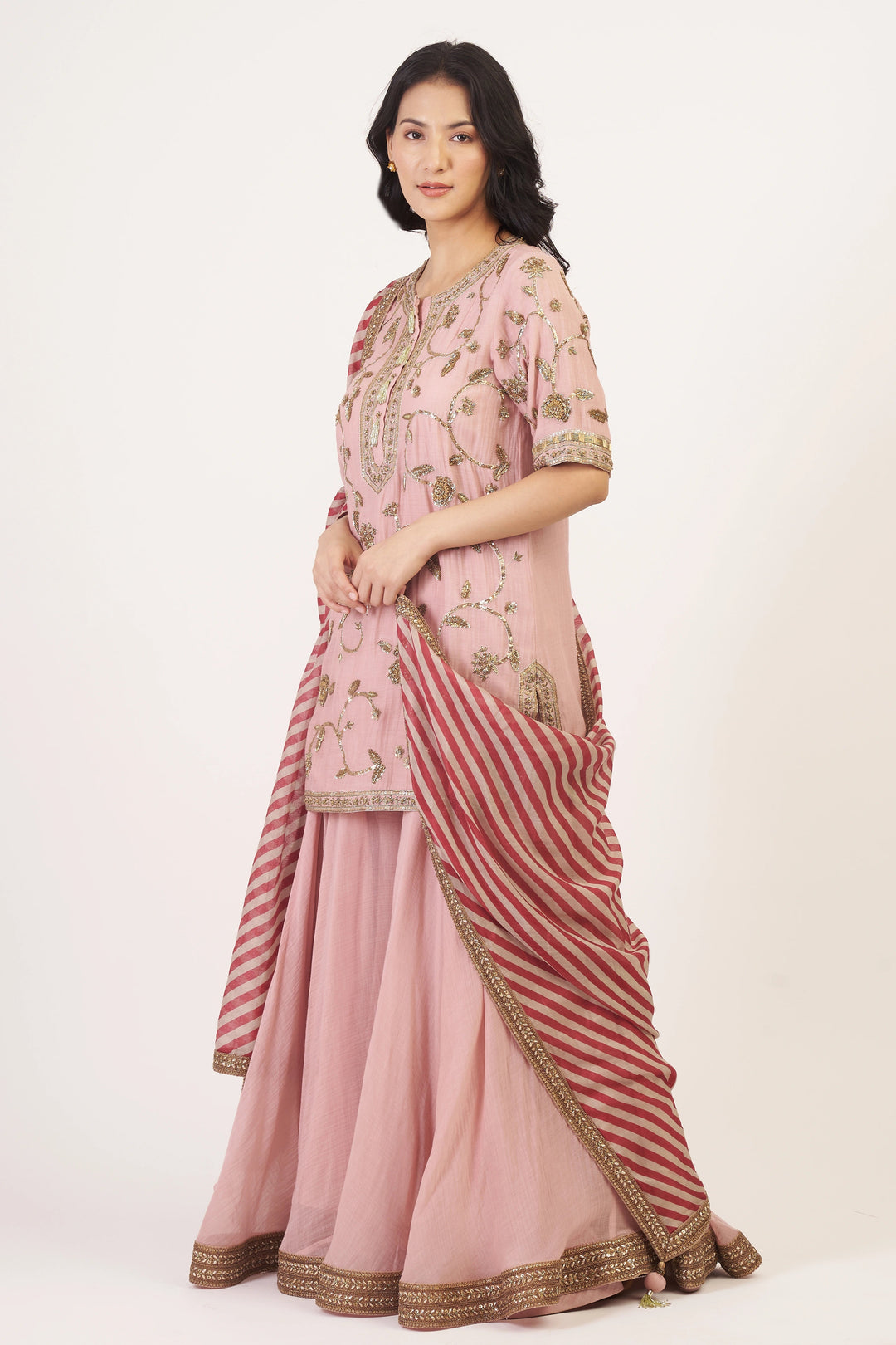 Woman wearing a pink traditional outfit with a white background
