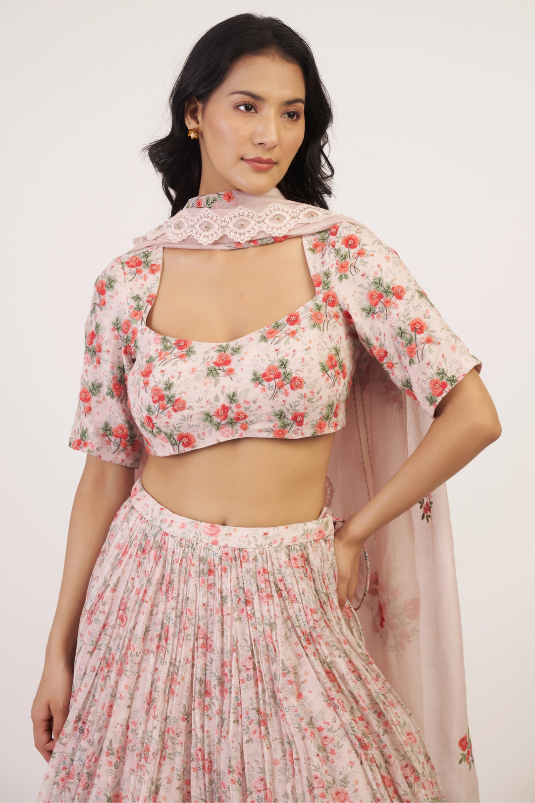 Woman wearing a floral outfit with a matching dupatta on a white background