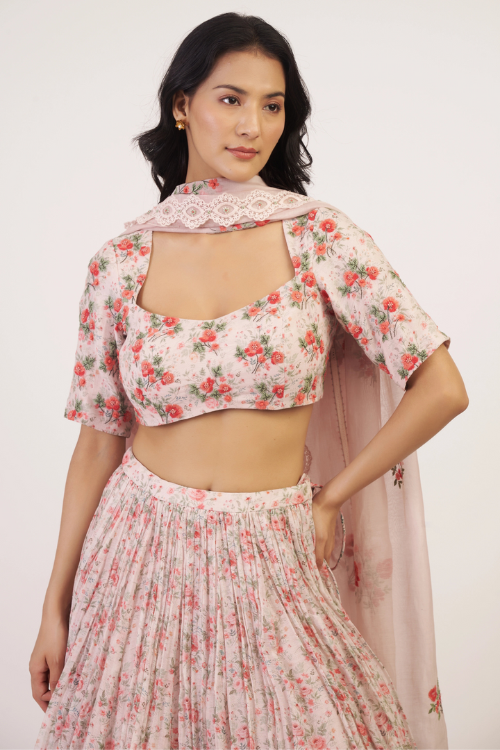 Woman wearing a floral outfit with a matching dupatta on a white background