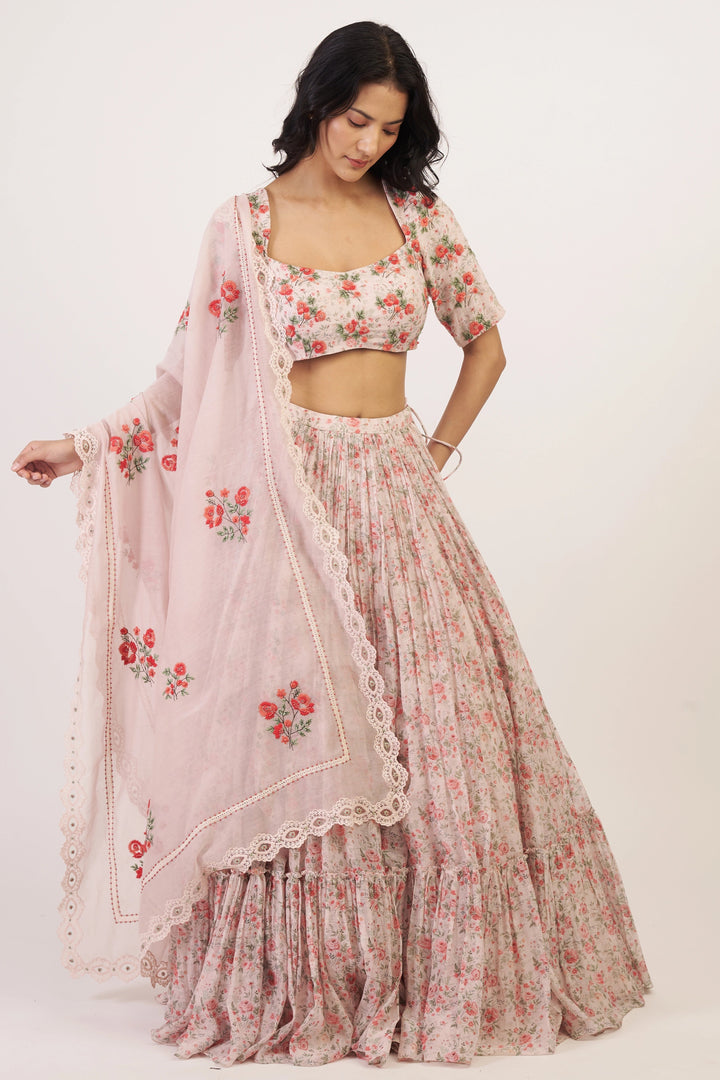 Woman wearing a floral outfit with a matching dupatta on a white background