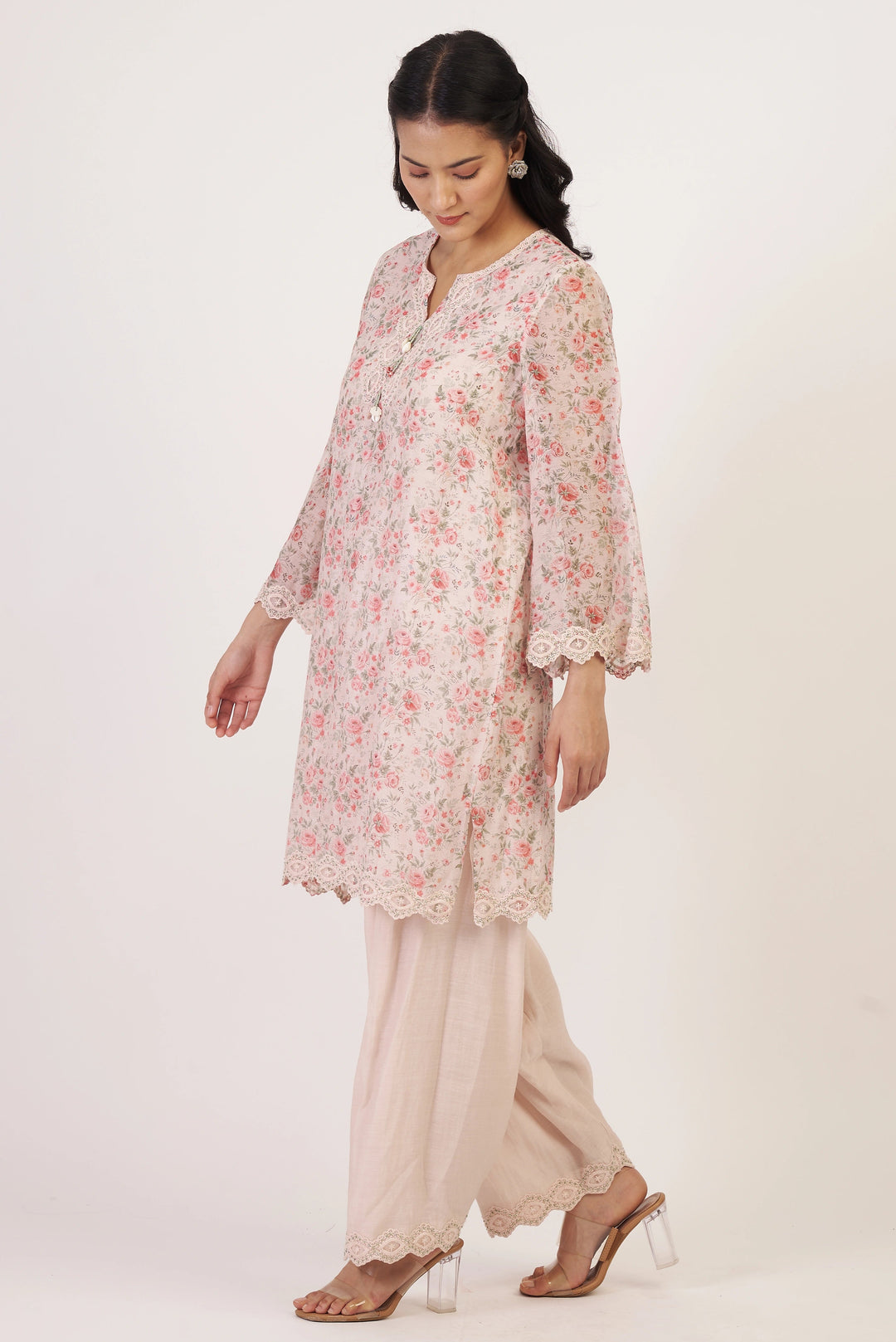 Woman wearing a floral kurta with beige pants on a white background