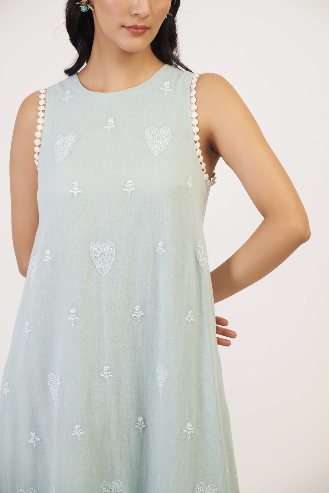 Light blue sleeveless dress with white floral patterns on a plain background