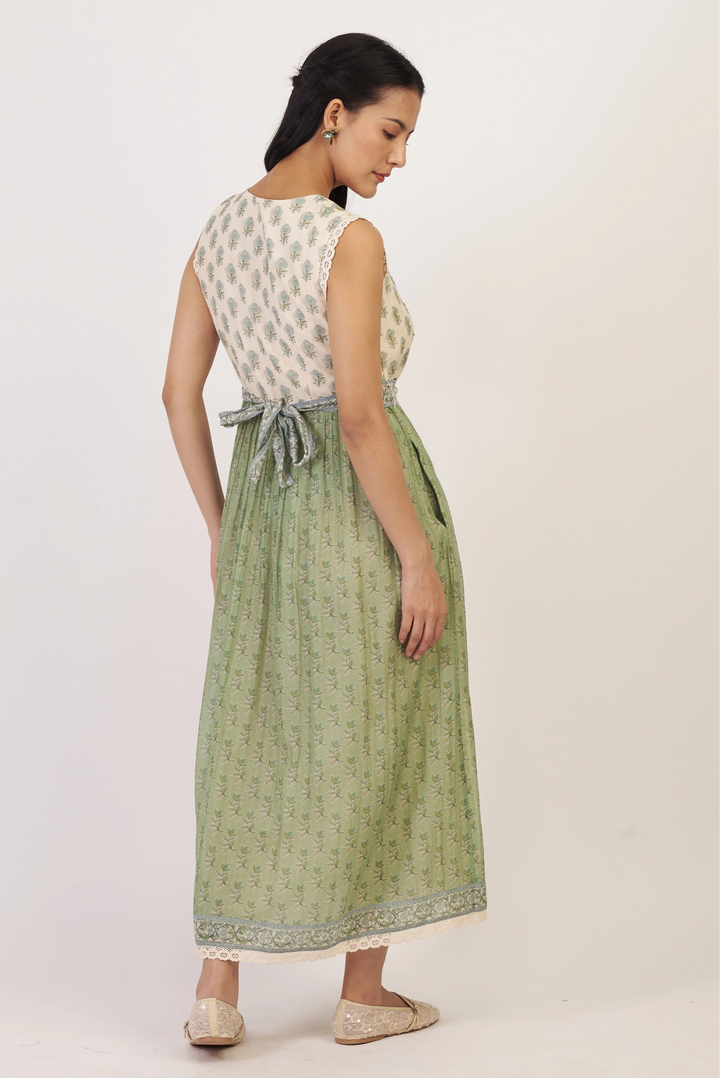 Woman wearing a sleeveless top and green skirt on a white background