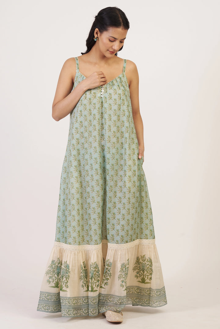 Woman wearing a green and beige patterned dress on a white background